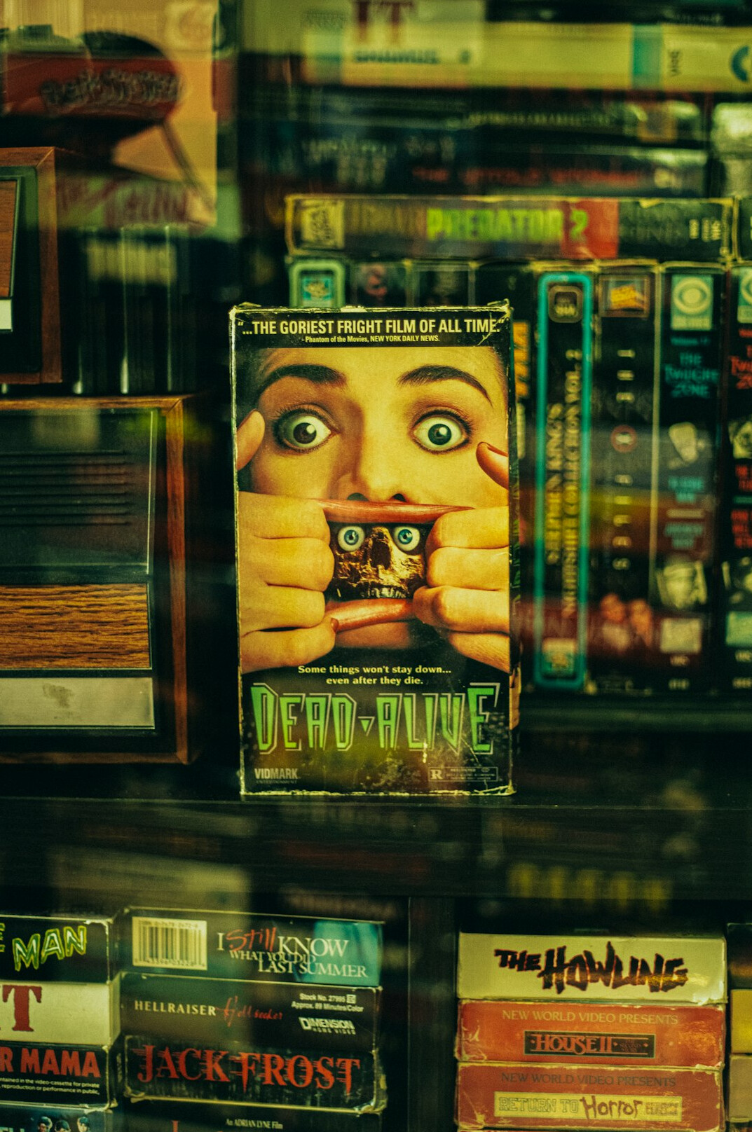 Archive shelf with vintage VHS tapes and advertising posters